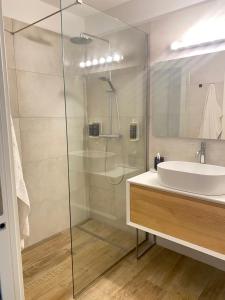 a bathroom with a glass shower and a sink at BOUTIQUE HOME LIGNANO in Lignano Sabbiadoro +22 photos