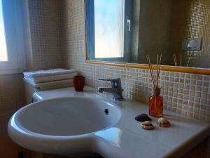 bagno con lavandino bianco e specchio di stella marina a Porto Recanati