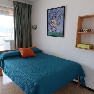 a bedroom with a bed with a blue comforter at Davant Del Mar in Palamós