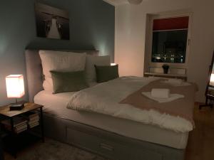 Schlafzimmer mit einem großen weißen Bett und einem Fenster in der Unterkunft Strand-Apartment, Strandkorb, Meeresrauschen, Parkplatz in Wilhelmshaven