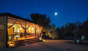 een huis met een terras 's nachts met de maan bij Zen Zone Premium Mobile Home in Drage