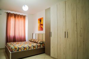 都拉斯Apartament Casas del Mar的一间卧室配有一张床和一个大型橱柜