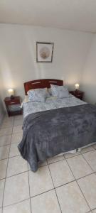 a bedroom with a bed and a tiled floor at Frente Al Parque Arauco in Santiago