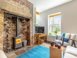 sala de estar con pared de ladrillo y chimenea en Top House, en Tideswell