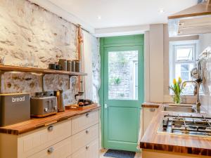 cocina con puerta verde y fregadero en Top House, en Tideswell