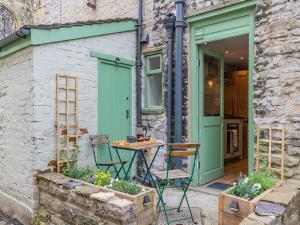 einen Tisch und Stühle außerhalb eines Gebäudes mit grüner Tür in der Unterkunft Top House in Tideswell