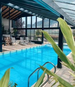 a large swimming pool with blue water in a building at Arelauquen Bungalows & Suites in San Carlos de Bariloche