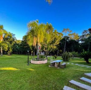 a park with a picnic table and benches in the grass at Recanto Vieira Praia do Estaleiro in Balneário Camboriú