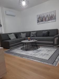 sala de estar con sofá negro y mesa en Bilino polje, en Zenica