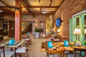 a restaurant with wooden tables and chairs and a brick wall at Pousada Don Diego in Ubatuba