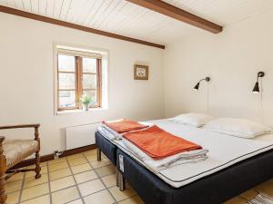 ein Schlafzimmer mit einem Bett, einem Fenster und einem Stuhl in der Unterkunft Holiday home Ebberup VI in Ebberup