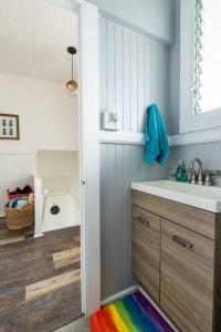 a bathroom with a sink and a rainbow rug at Somewhere over the Rainbow Loft with AC Hilo in Hilo +27 photos