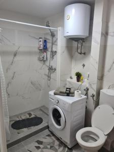 a bathroom with a washing machine and a toilet at Bilino polje in Zenica