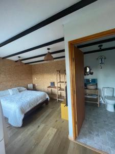 1 dormitorio con 1 cama grande y baño en Cabaña Rural con excelente vista en Duitama