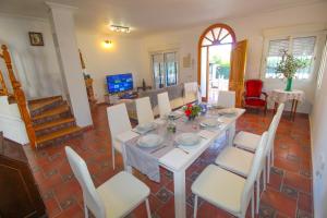 a dining room with a white table and white chairs at Great villa, Sea views, 20 secs walk to the beach, BBQ, 9 people, 5 mins car from Alicante city center, sailing club 3 mins walk in Alicante