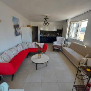 een woonkamer met een rode bank en een tafel bij Marmaristeki Eviniz 