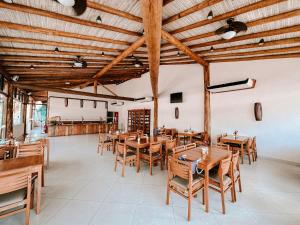 a dining room with wooden tables and chairs at Abricó Beach Hotel in São Sebastião