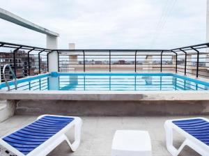 a swimming pool on top of a building with two chairs at MIRADOR PANORAMICO-DEPTO TUCUMAN in San Miguel de Tucumán