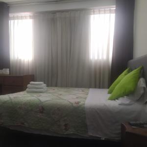 una camera da letto con un letto con cuscini verdi di Casa Artesana a Cuzco