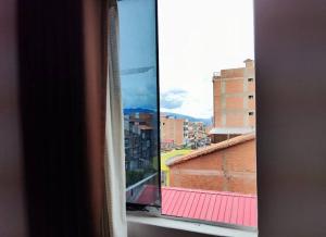 een raam met uitzicht op de stad bij Casa Artesana in Cuzco