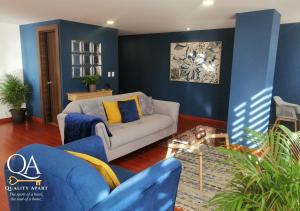 sala de estar con paredes azules y sofá en Quality Apart, Exclusive Penthouses en Cuenca
