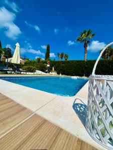 uma piscina num resort com uma palmeira em Nicole Luxury Villas em Koskinou