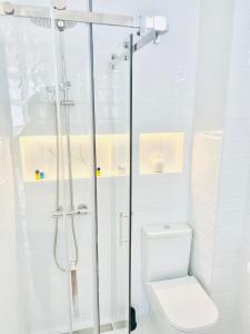 a white bathroom with a shower and a toilet at Ático Luz de Córdoba PARKING GRATIS CENTRO in Córdoba