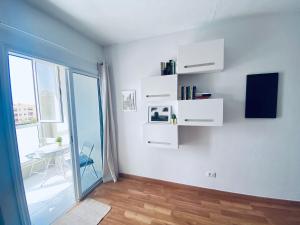 Habitación con estanterías blancas, mesa y ventana en MÉDANO LOVER By TOP STAY, en El Médano