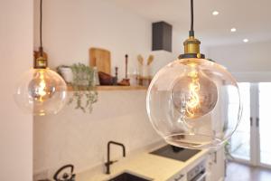 a kitchen with three lights hanging from the ceiling at Boutique Fisherman’s Cottage in Cullercoats