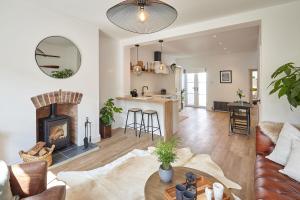 a living room with a fireplace and a kitchen at Boutique Fisherman’s Cottage in Cullercoats