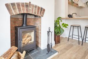 a brick fireplace in a living room with a stove at Boutique Fisherman’s Cottage in Cullercoats