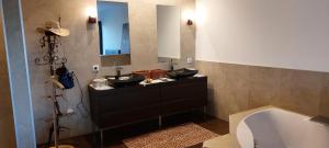 une salle de bain avec deux lavabos et une baignoire dans l'établissement La baie des anges, à Porto-Vecchio 83 autres photos