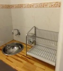 a bathroom with a metal sink and a wooden floor at Monoambiente Centrico Amplio in Tandil
