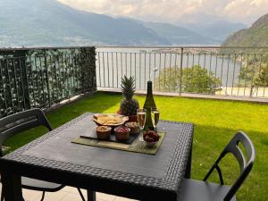 a table with food and a bottle of wine and a pineapple at Belvedere in Costa - Lake View in Bellano