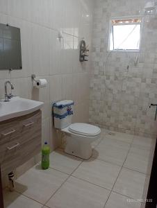 uma casa de banho com um WC, um lavatório e um chuveiro em CHÁCARA TERRA dos SONHOS em Guaratinguetá