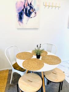 a table with chairs and a painting of a dog at Perfect modern Townhouse CBD Christchurch in Christchurch