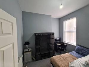a bedroom with a bed and a desk and a window at The MEWS 4BR 2BA, FREE PARKING FOR 1 VEHICLE SLEEPS 8 in Liverpool