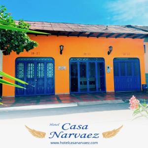 an orange building with blue doors on it at Hotel casa Narvaez in Girardot