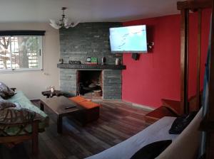 sala de estar con chimenea y TV de pantalla plana en Casa Caballito Azul en Balneario Mar Azul