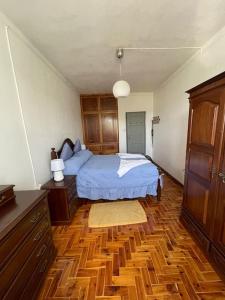 um quarto com uma cama e piso em madeira em Casa da Celeste em Maljoga de Proença