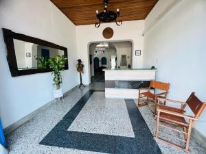 a living room with a mirror and a chair at Hotel casa Narvaez in Girardot