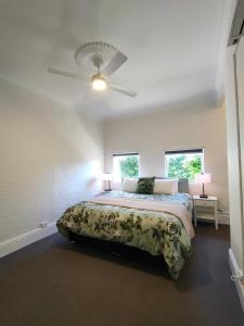 1 dormitorio con 1 cama y ventilador de techo en Windarra on High, en Launceston