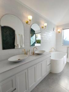 uma casa de banho com dois lavatórios e dois espelhos em Windarra on High em Launceston