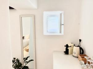 un espejo sentado en un mostrador junto a una pared blanca en Esmi Suites Santorini en Imerovigli