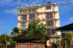 Un edificio alto con un árbol delante. en Goa Ganesha, en Nusa Dua