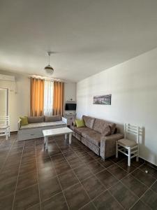 a living room with a couch and a table at Marjana's Apartment 3 in Lezhë +20 photos