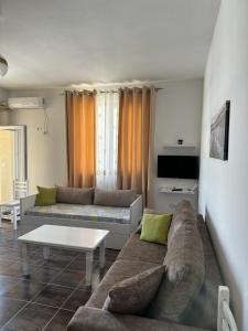 a living room with a couch and a table at Marjana's Apartment 3 in Lezhë