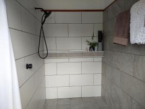 a white tiled shower with a shower curtain in a bathroom at Corner Cottage Rear Studio - Geneva in Kyogle in Kyogle