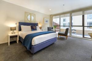 a bedroom with a large bed and a large window at U Residence Hotel in Wellington