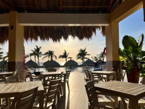 een restaurant met tafels en stoelen en uitzicht op het water bij Samaria Club de Playa in Santa Marta
